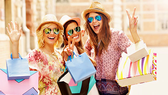 Happy smiling women holding shopping bags